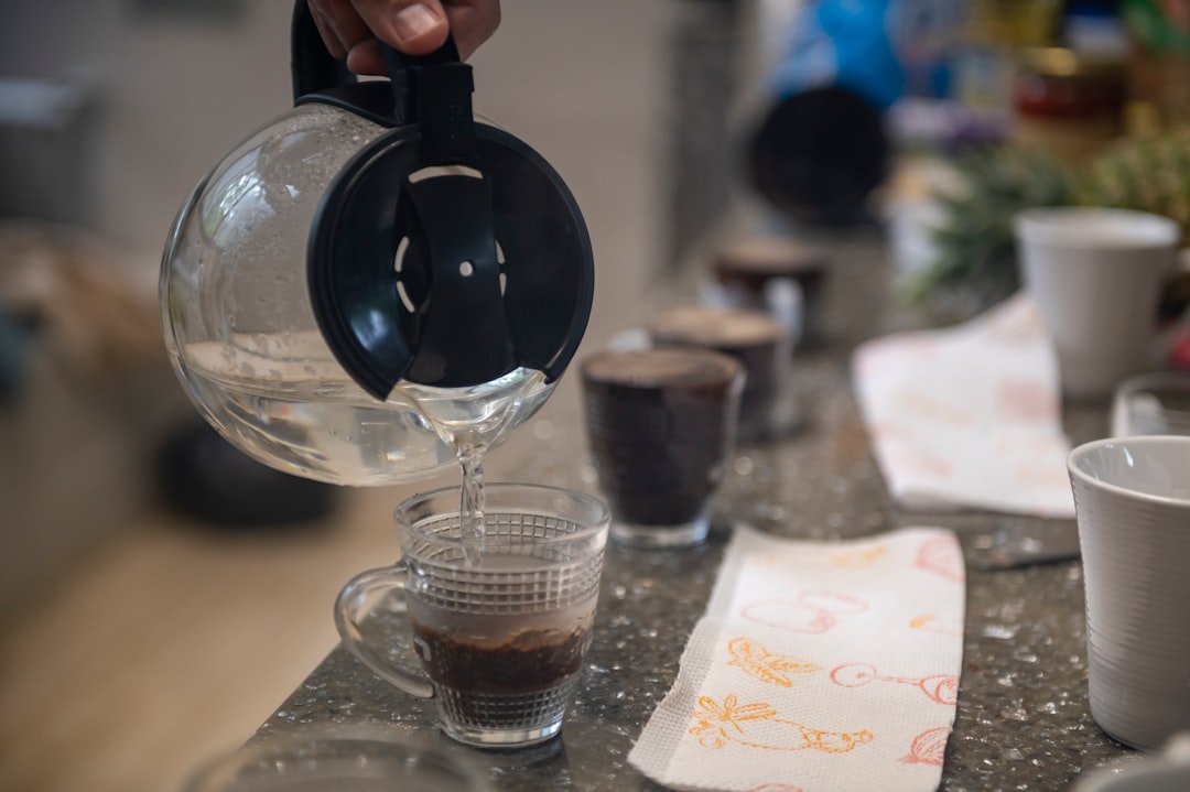 A person pours coffee into a glass