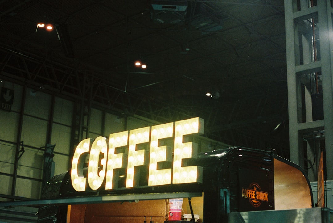 A lit "coffee" sign at night.