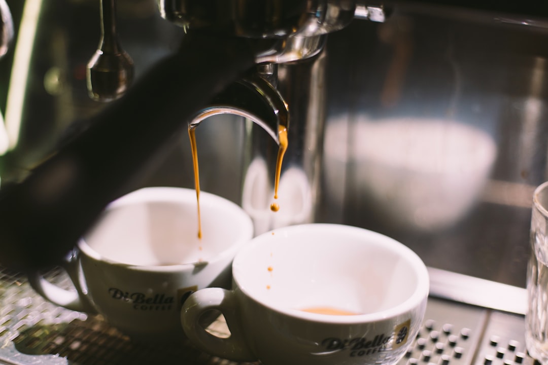Two white ceramic mugs on coffeemaker